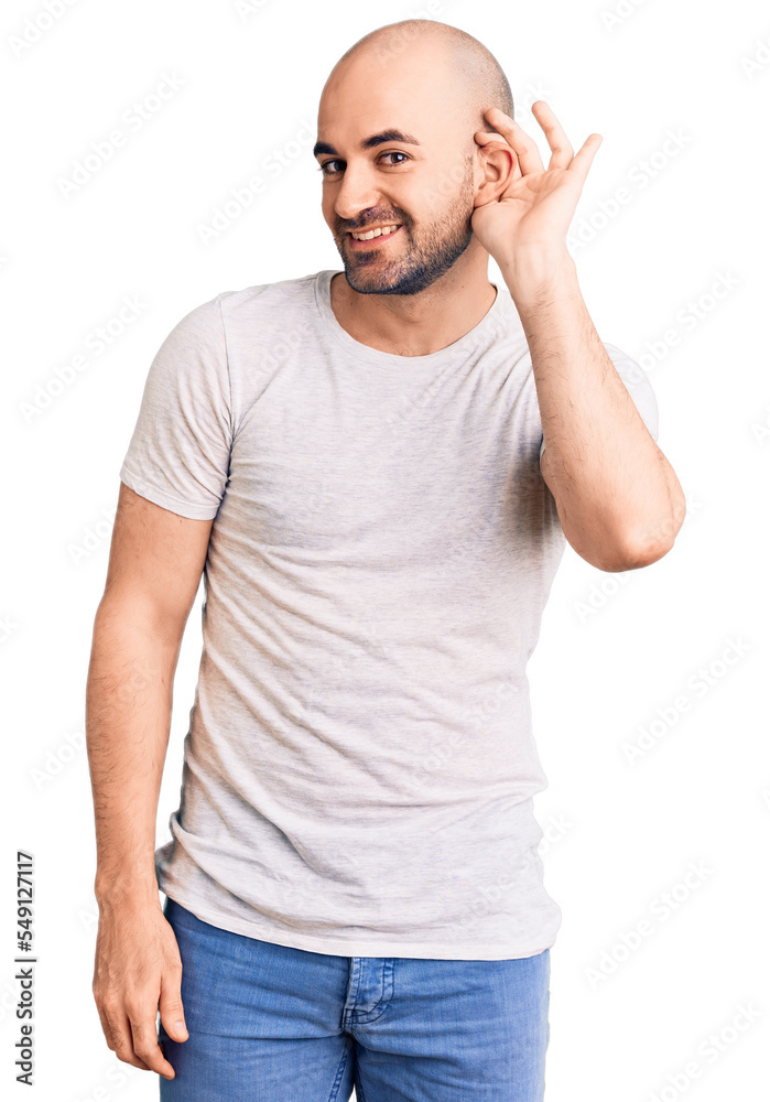 Young handsome man wearing casual t shirt smiling with hand over ear listening an hearing to rumor or gossip. deafness concept. Young handsome man wearing casual t shirt smiling with hand over ear listening an hearing to rumor or gossip. deafness concept.