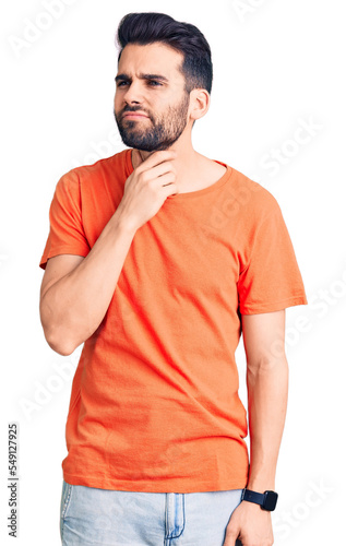 Young handsome man with beard wearing casual t-shirt touching painful neck, sore throat for flu, clod and infection