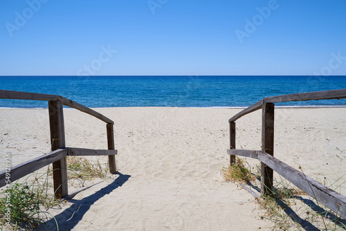 Jetty to Ascea beach in the Salerno region of southern Italy. An empty beach with beautiful sea and blue sky. Space for text.
