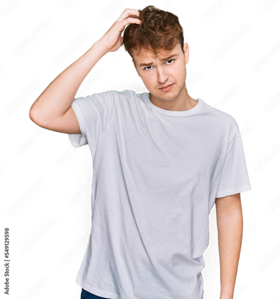 Young caucasian man wearing casual white t shirt confuse and wonder about question. uncertain with doubt, thinking with hand on head. pensive concept. Young caucasian man wearing casual white t shirt confuse and wonder about question. uncertain with doubt, thinking with hand on head. pensive concept.