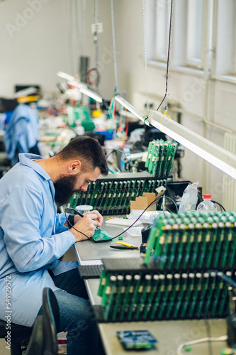 Electronics engineer working in a workshop with tin soldering parts photo