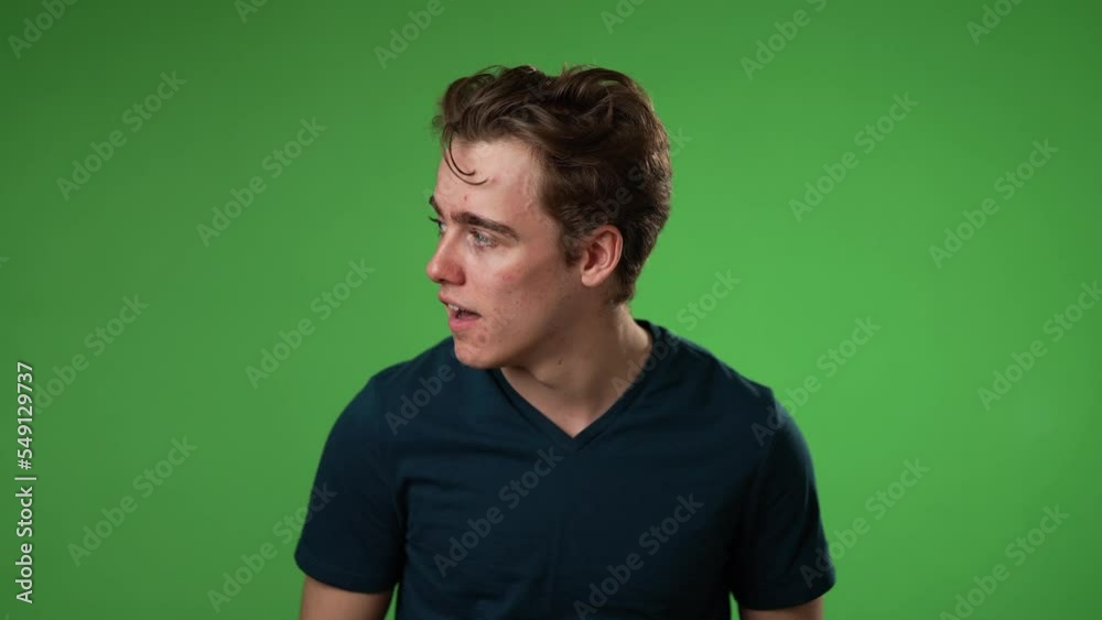 Portrait of happy smiling young man 20s smiling and look around for friend find meet greet and notices someone isolated on green screen background.