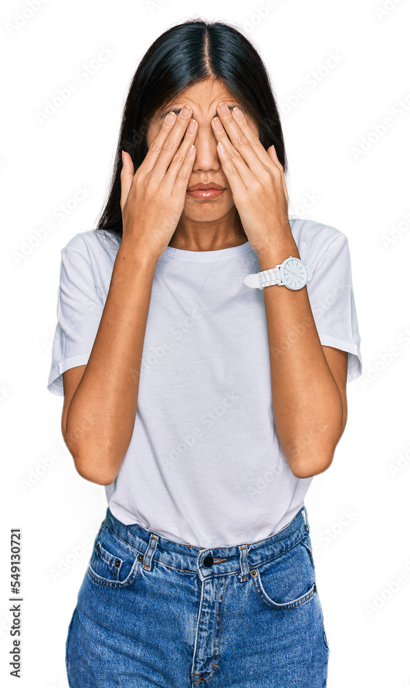 Beautiful young asian woman wearing casual white t shirt rubbing eyes for fatigue and headache, sleepy and tired expression. vision problem Beautiful young asian woman wearing casual white t shirt rubbing eyes for fatigue and headache, sleepy and tired expression. vision problem