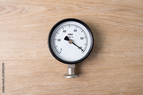 close up of pressure gauge on wooden table background, engineering equipment concept