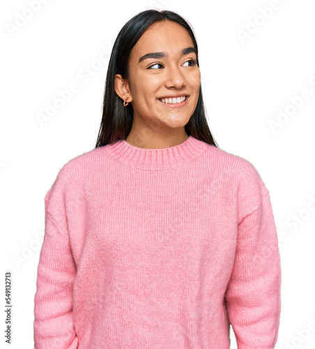 Young asian woman wearing casual winter sweater looking away to side with smile on face, natural expression. laughing confident.