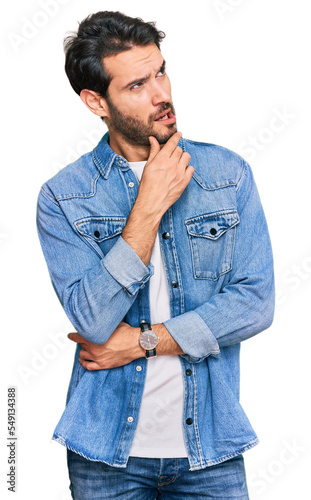 Young hispanic man wearing casual clothes thinking worried about a question, concerned and nervous with hand on chin