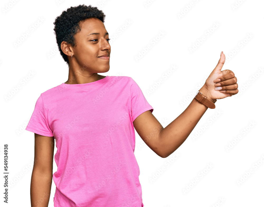 Young african american woman wearing casual clothes looking proud, smiling doing thumbs up gesture to the side Young african american woman wearing casual clothes looking proud, smiling doing thumbs up gesture to the side