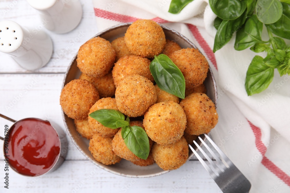 Bowl of delicious fried tofu balls with basil and sauce on white wooden table, flat lay Bowl of delicious fried tofu balls with basil and sauce on white wooden table, flat lay