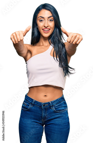 Beautiful hispanic woman wearing casual clothes approving doing positive gesture with hand  thumbs up smiling and happy for success. winner gesture.