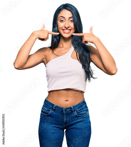 Beautiful hispanic woman wearing casual clothes smiling cheerful showing and pointing with fingers teeth and mouth. dental health concept.