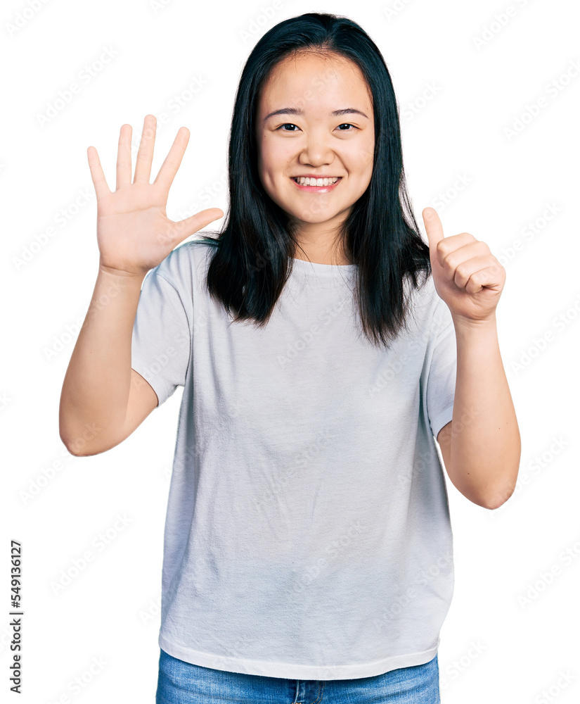 Young chinese woman wearing casual white t shirt showing and pointing up with fingers number six while smiling confident and happy. Young chinese woman wearing casual white t shirt showing and pointing up with fingers number six while smiling confident and happy.