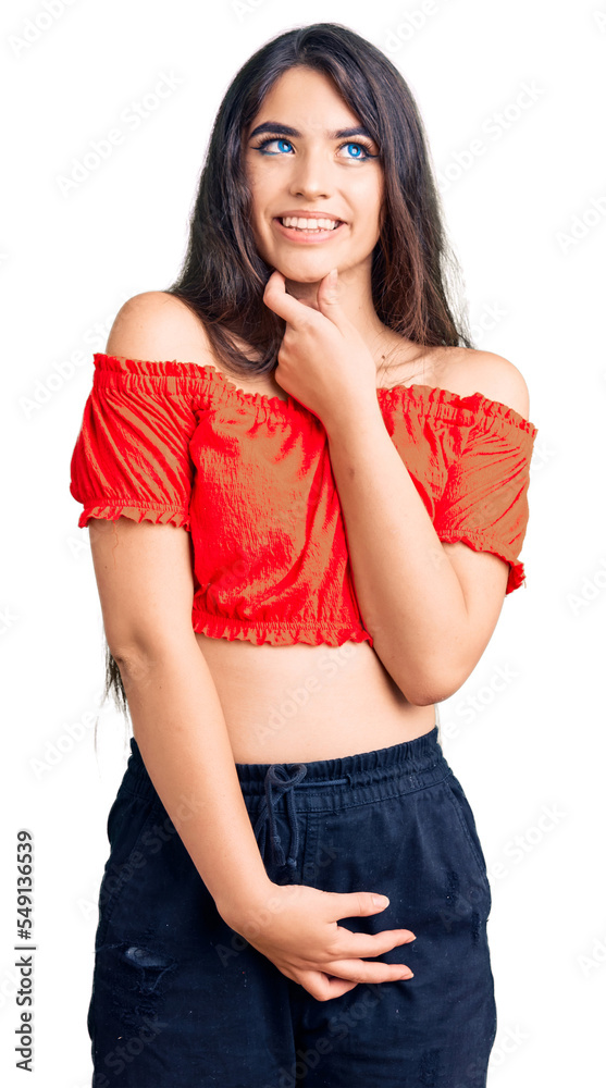 Fototapeta premium Brunette teenager girl wearing casual clothes with hand on chin thinking about question, pensive expression. smiling with thoughtful face. doubt concept.
