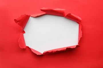 Hole in red paper on white background