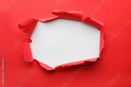 Hole in red paper on white background