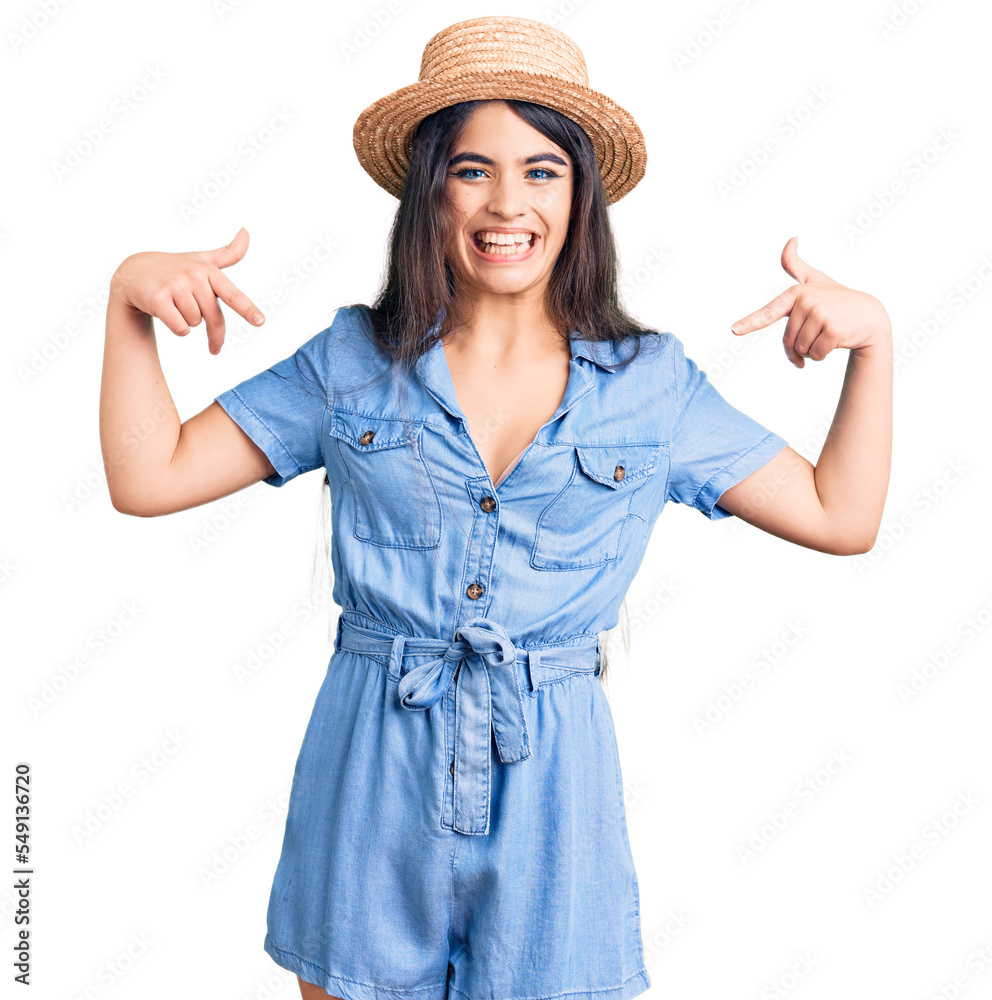 Brunette teenager girl wearing summer hat looking confident with smile on face, pointing oneself with fingers proud and happy. Brunette teenager girl wearing summer hat looking confident with smile on face, pointing oneself with fingers proud and happy.