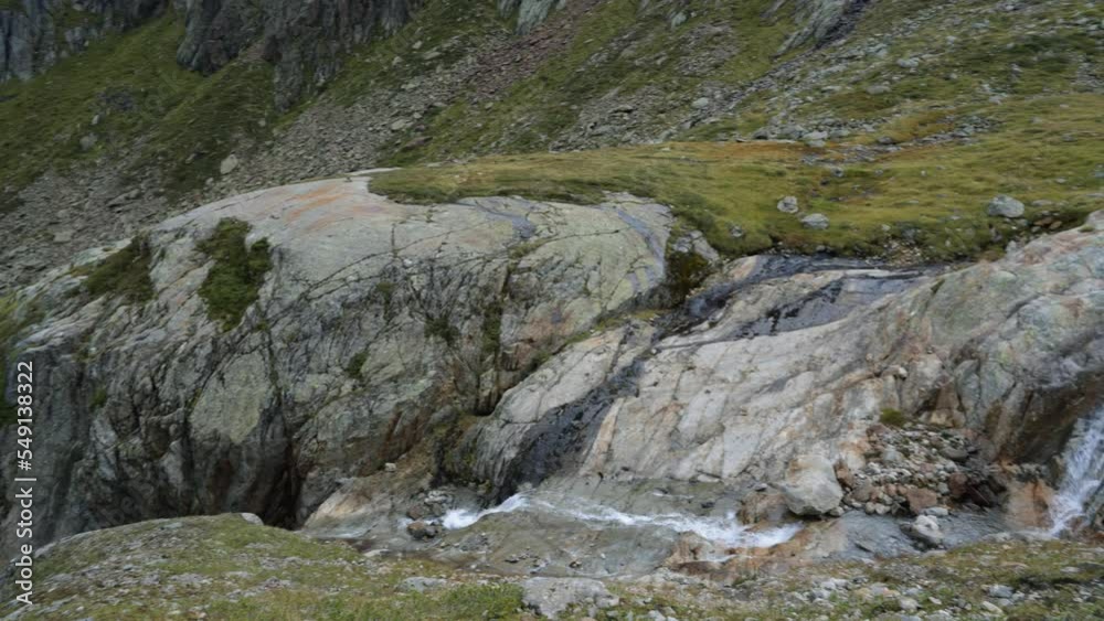 The alow flow of water in the mountains in calm nature with a moody scenery. Hiking through crystal clear glacier water when it melts. The alow flow of water in the mountains in calm nature with a moody scenery. Hiking through crystal clear glacier water when it melts.