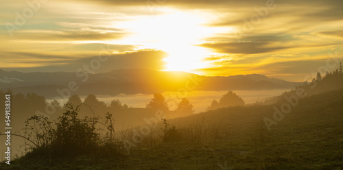 sunrise over a mountain below a misty valley 