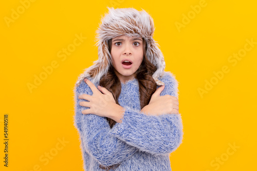 Fototapeta cold child in sweater and earflap hat on yellow background, cold