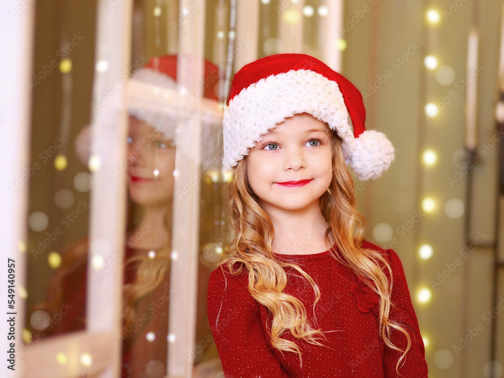 Little girl dreams of Christmas at the window Little girl dreams of Christmas at the window