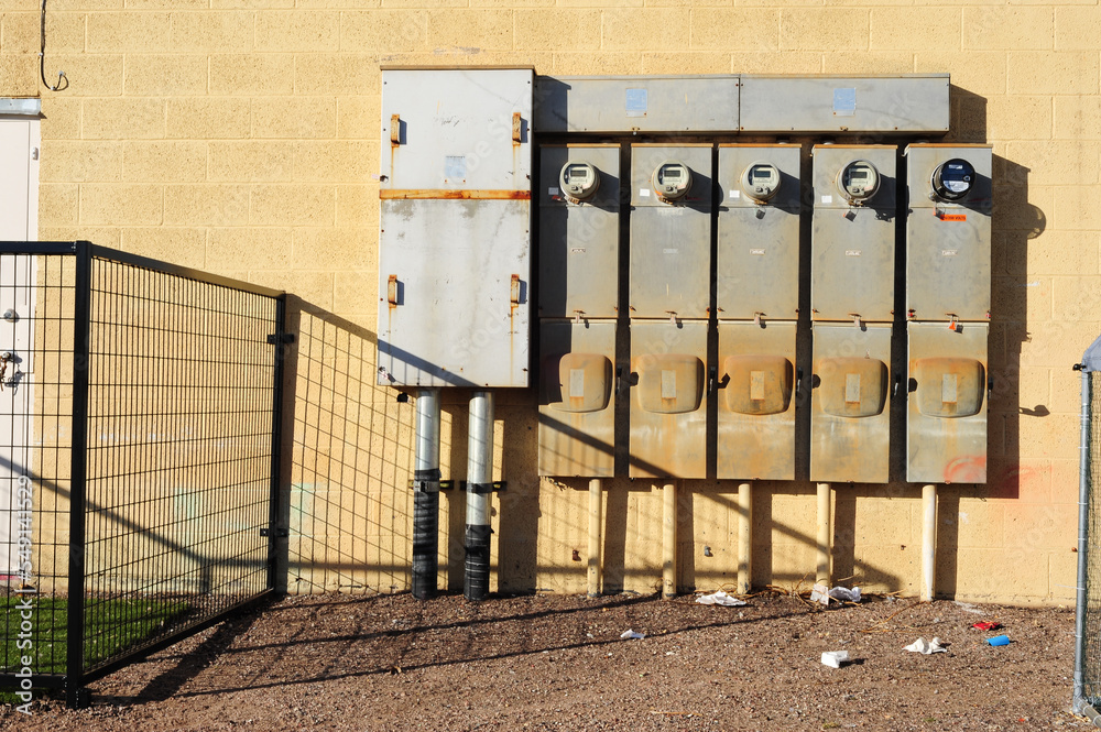 Cluster of electric meters on exterior block wall of strip mall