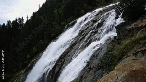 The alow flow of water in the mountains in calm nature with a moody scenery. Hiking through crystal clear glacier water when it melts. photo