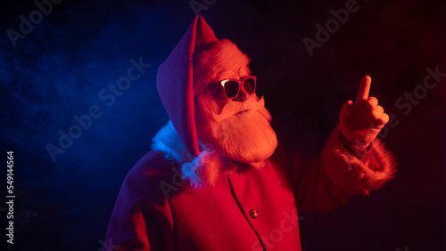 Fotografie, Obraz Portrait of Santa Claus in sunglasses in neon light.