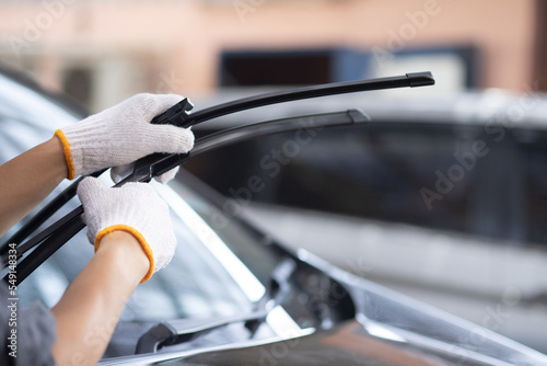 Cuadro en lienzo A mechanic wearing white gloves changes the wiper blades