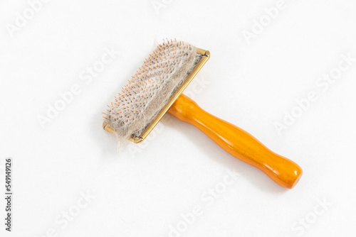 Cat brush with cat hair clump isolated on white background.