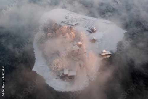 Aerial view of an island shrouded in winter fog on the Angara River