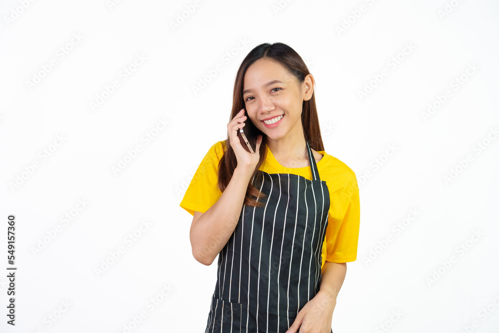 Call a mobile phone with customer, Portrait of confident asian woman barista and food owner shop with yellow t-shirt and black apron standing on white background. Call a mobile phone with customer, Portrait of confident asian woman barista and food owner shop with yellow t-shirt and black apron standing on white background.