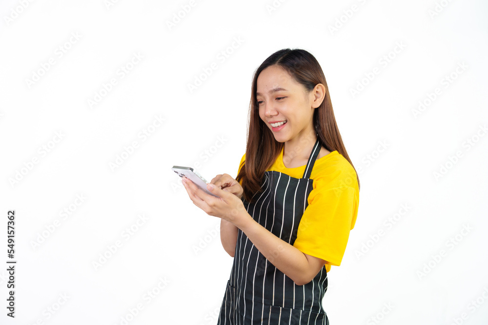 Received customer online order on mobile app, Portrait of confident asian woman barista and food owner shop with yellow t-shirt and black apron standing on white background. Received customer online order on mobile app, Portrait of confident asian woman barista and food owner shop with yellow t-shirt and black apron standing on white background.