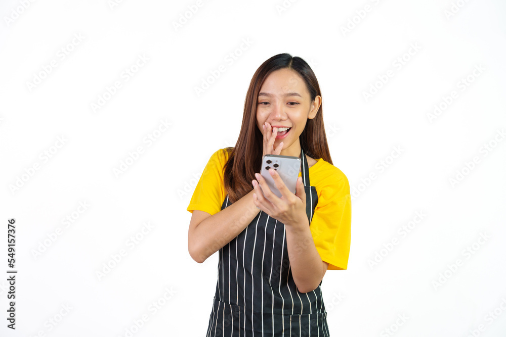 Received customer online order on mobile app, Portrait of confident asian woman barista and food owner shop with yellow t-shirt and black apron standing on white background. Received customer online order on mobile app, Portrait of confident asian woman barista and food owner shop with yellow t-shirt and black apron standing on white background.