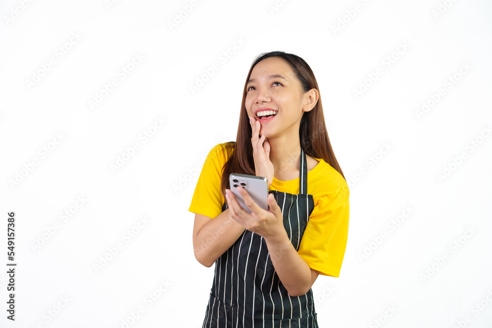 Received customer online order on mobile app, Portrait of confident asian woman barista and food owner shop with yellow t-shirt and black apron standing on white background. Received customer online order on mobile app, Portrait of confident asian woman barista and food owner shop with yellow t-shirt and black apron standing on white background.