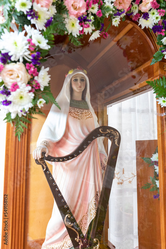 Santa Cecilia religious figure with decorative flowers. Santa Cecilia is the patron of musicians