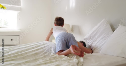 Morning, father and boy play in bed, happy or smile for bonding and love. Man, son and family home with dad, excited and bedroom with laugh, playing or comic time in home, tickle and happiness photo