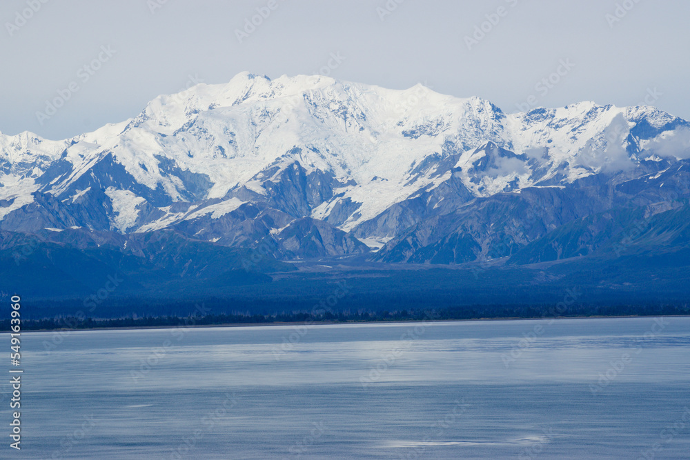 Snowy mountains at waters edge in alaska 