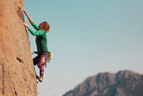 the girl is engaged in rock climbing. sports in nature.