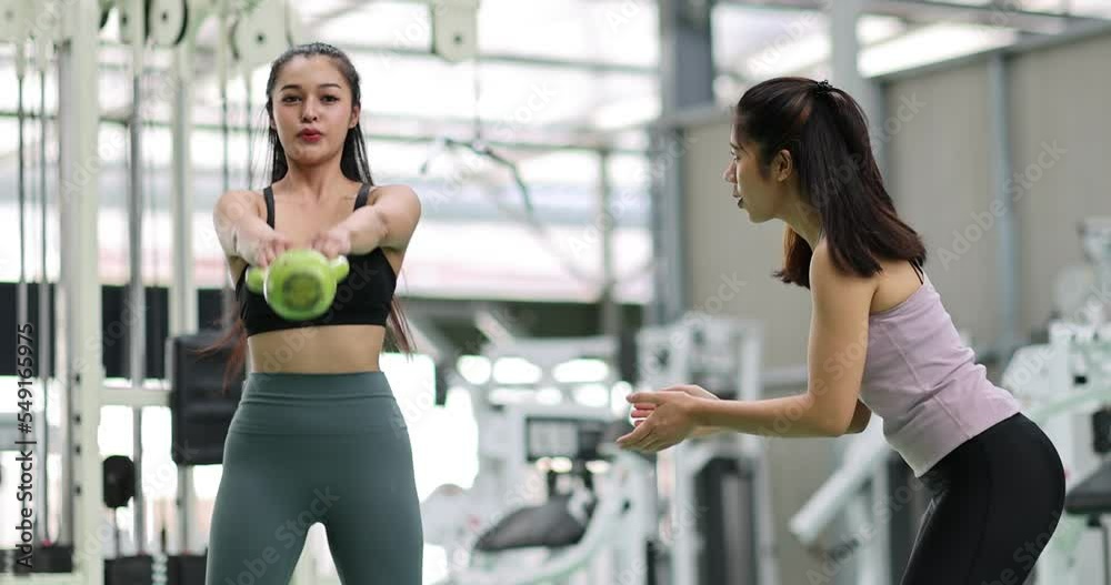 Asian woman exercise with personal trainer in gym. Young healthy woman workout in fitness with personal coach. Exercises and fitness GYM concept. Asian woman exercise with personal trainer in gym. Young healthy woman workout in fitness with personal coach. Exercises and fitness GYM concept.