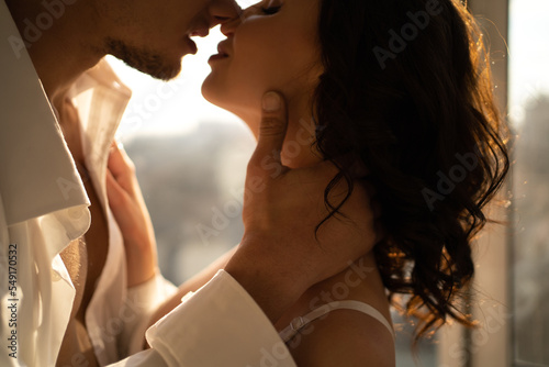 Принти на полотні Portrait of a beautiful couple kissing in the morning at the window, romantic da