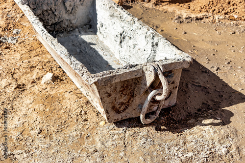 A special container in the form of a trough for supplying mortar or concrete at a construction site. A device for delivering mortar by a crane to a height for brickwork. photo