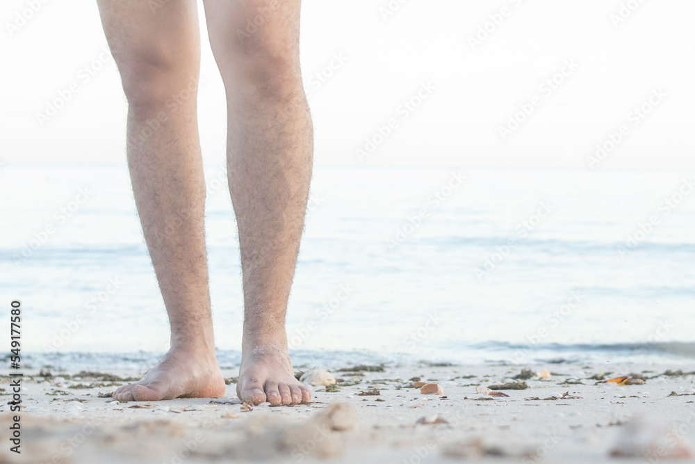 Barefoot male legs stand on the wet coastal sand on the shores of Puerto Progreso yucatan, mexico Barefoot male legs stand on the wet coastal sand on the shores of Puerto Progreso yucatan, mexico