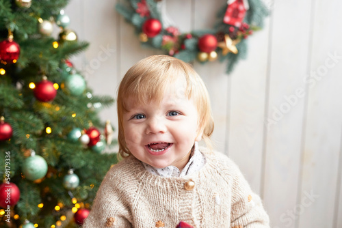 Santa baby. Beautiful child. Merry christmas and happy new year. Christmas tree background.
