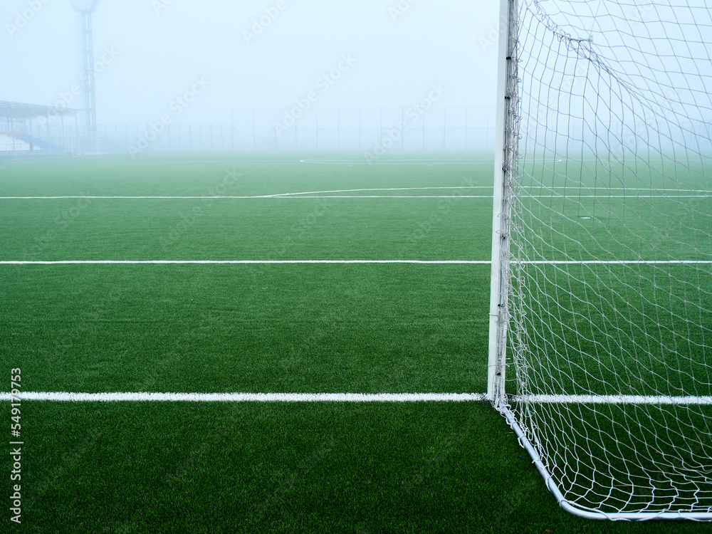 football field in the fog. green lawn and football field markings