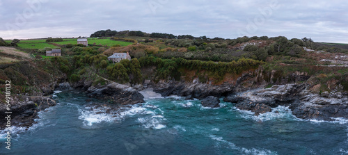 Beautiful aerial drone landscape image of Prussia Cove at sunrise in Cornwall England with atmospheric daramatic sky and clouds