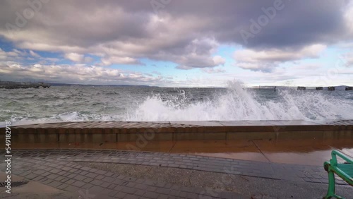 Waves crash the seawall on a blustery cold day.