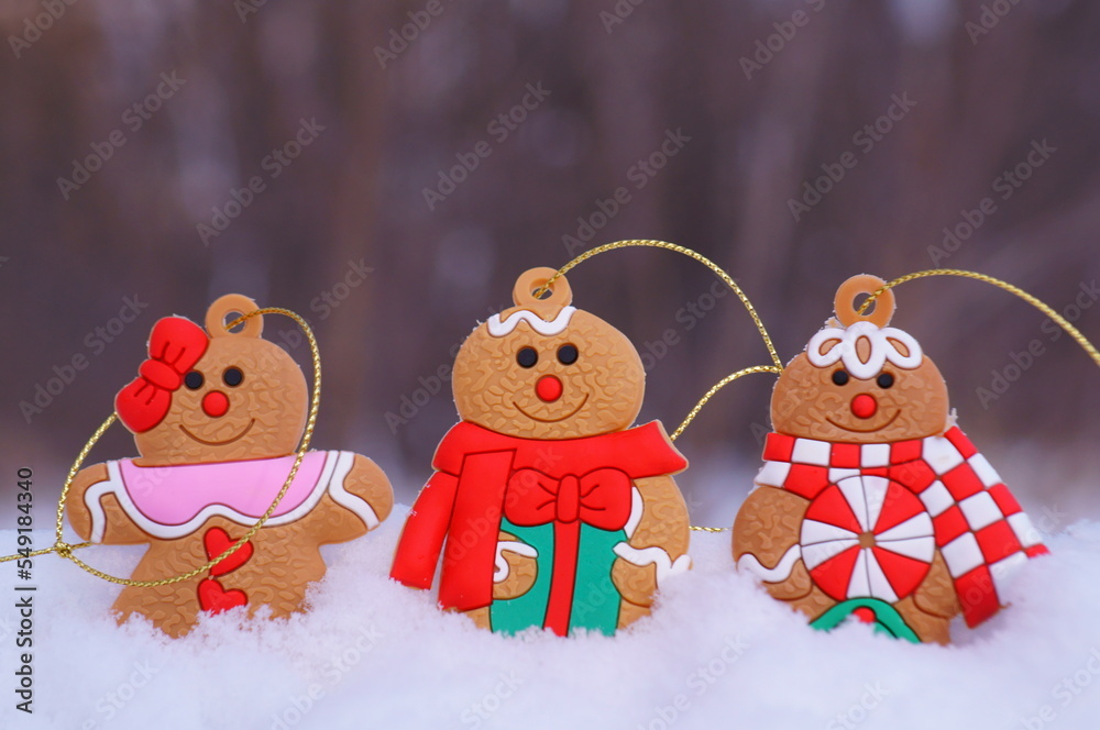 Naklejka premium Three gingerbread decorated men on a background of snow. Christmas decorations.