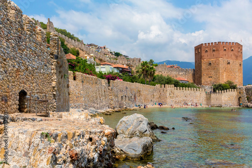 The Red Tower (Kizil Kule) and citadel wall as seen from the ancient shipyard. Medieval fortress, pupular tourist point. Alanya (Antalya district), Turkey (Turkiye) photo