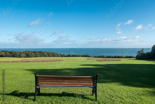 Wooden bench overlooking a beautiful sunny view of the ocean, Ireland