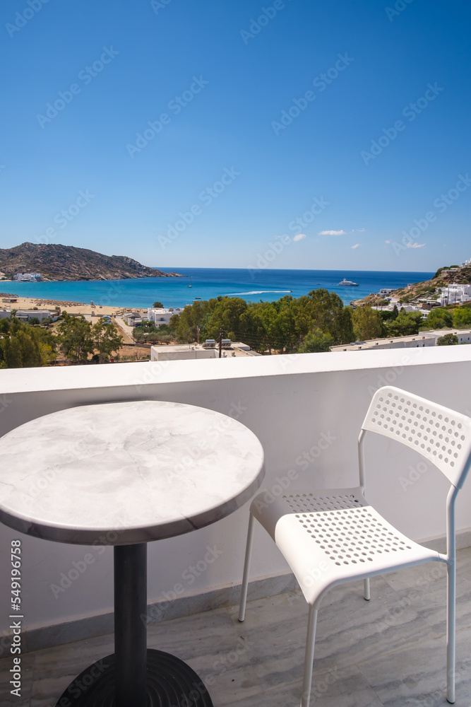 Amazing view from a balcony with chairs and a table overlooking the famous Mylopotas beach in Ios Greece 
