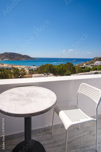 Amazing view from a balcony with chairs and a table overlooking the famous Mylopotas beach in Ios Greece 